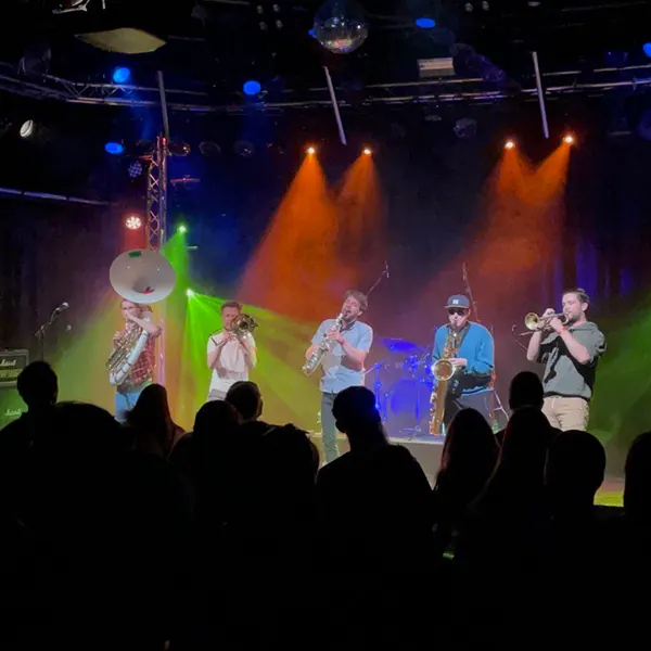 Duke Brass spielt auf einer farbig beleuchteten Bühne vor Publikum